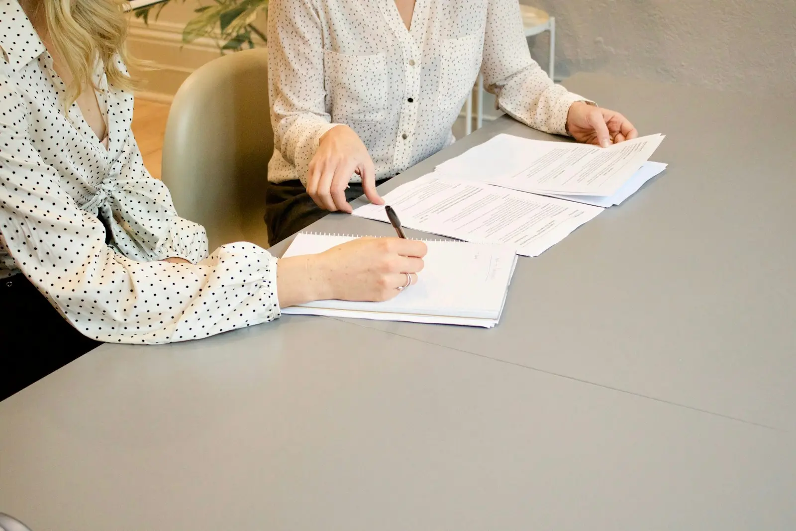 Deux personnes relisent des documents autour d'une table